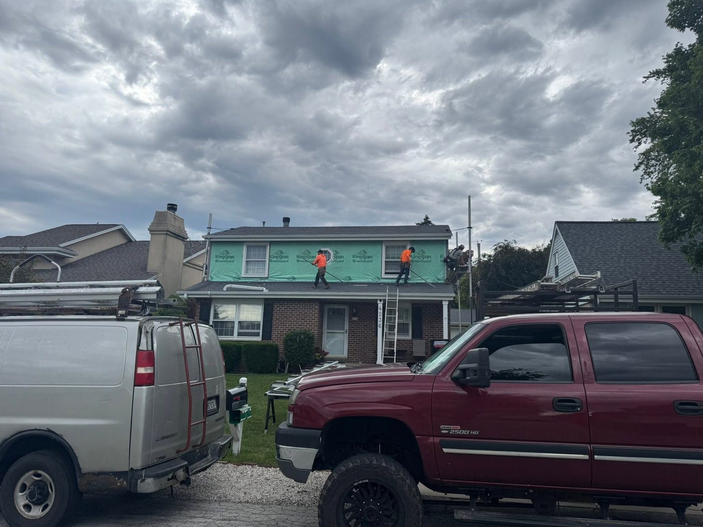 Evergreen crew installing siding